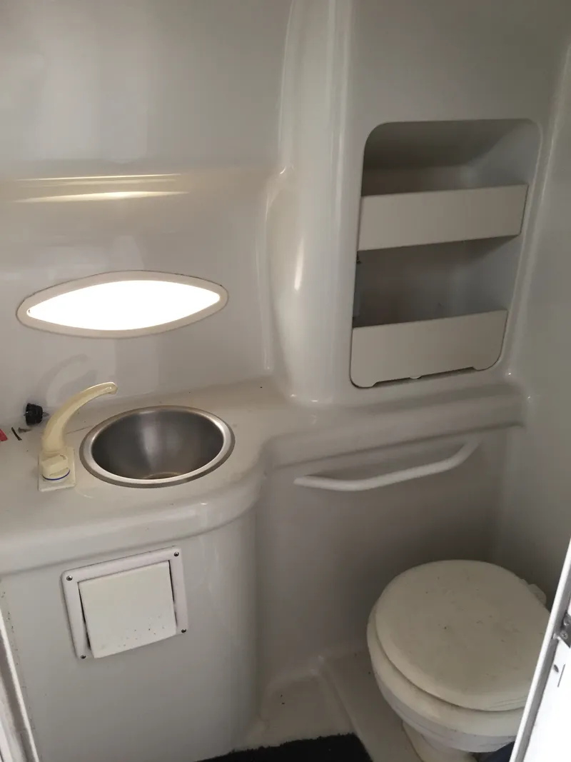 Slide: The Image of 1992 Chris-Craft 232 Crowne boat bathroom with sink, toilet, and storage shelves. - 8