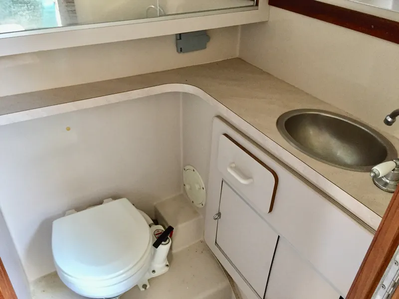 Slide: The Image of 1993 Regal 300 Commodore bathroom with toilet, sink, and storage cabinets. - 11