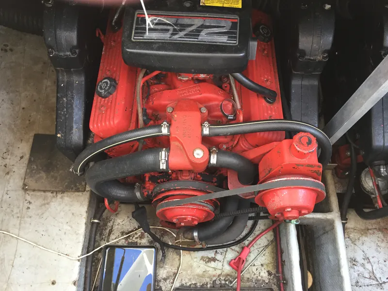 Slide: The Image of Engine of a 1993 Regal 300 Commodore boat, featuring red components and visible hoses. - 12