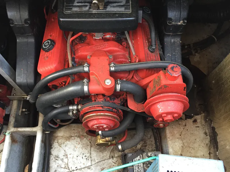 Slide: The Image of Engine of a 1993 Regal 300 Commodore boat, featuring red components and hoses. - 13