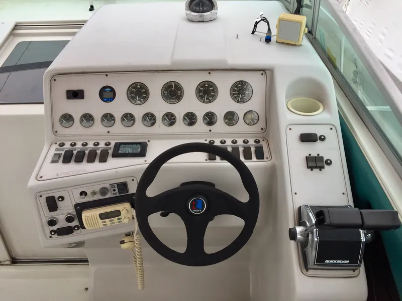 Slide: The Image of 1993 Regal 300 Commodore boat dashboard with steering wheel and control panel. - 4