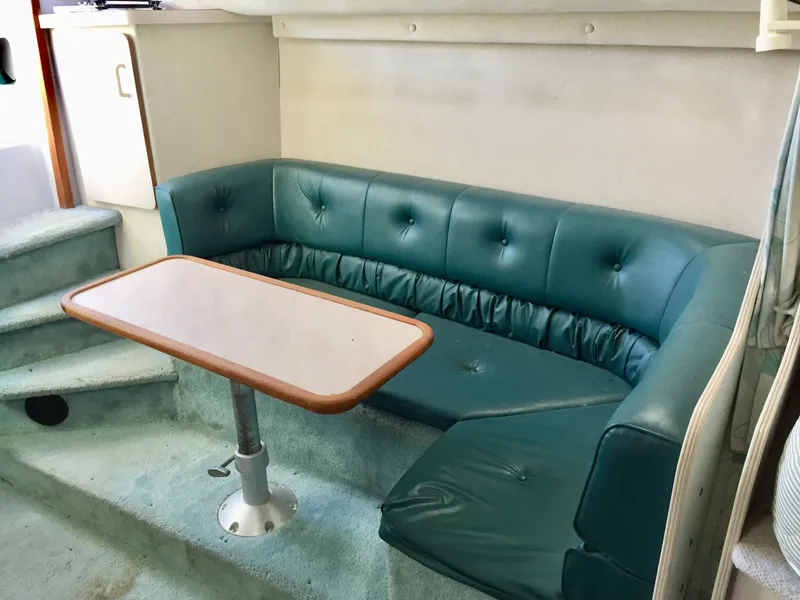 Slide: The Image of 1993 Regal 300 Commodore interior with teal seating and a wooden table. - 8
