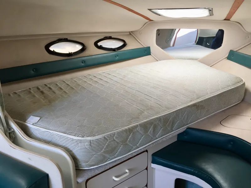 Slide: The Image of 1993 Regal 300 Commodore cabin interior with bed and portholes. - 9