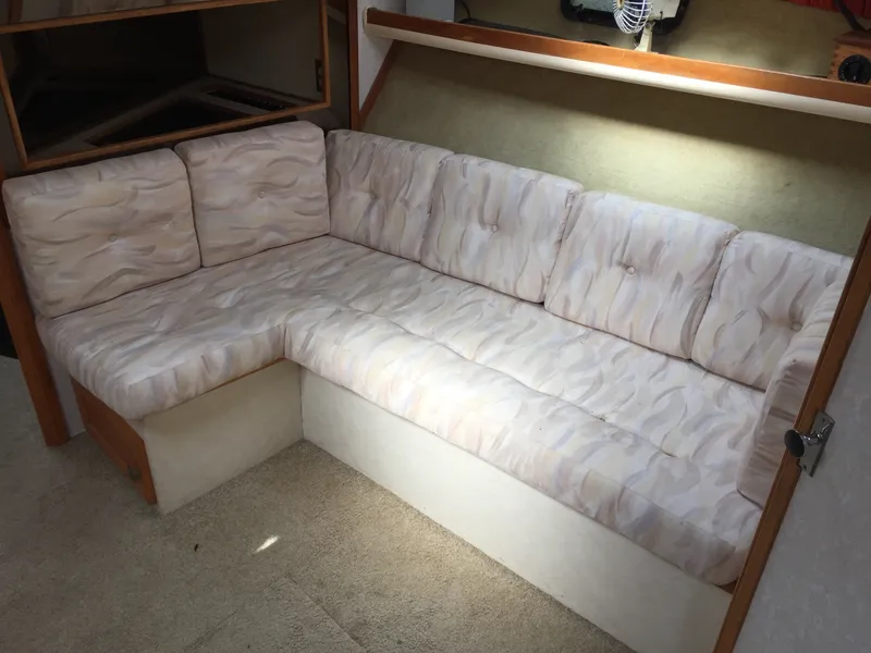 Slide: The Image of 1981 Bayliner 3250 Conquest Sunbridge interior with L-shaped cushioned seating. - 11