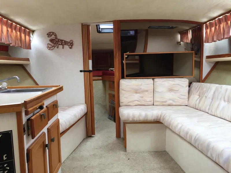 Slide: The Image of Interior of 1981 Bayliner 3250 Conquest Sunbridge with seating, kitchenette, and cozy decor. - 7