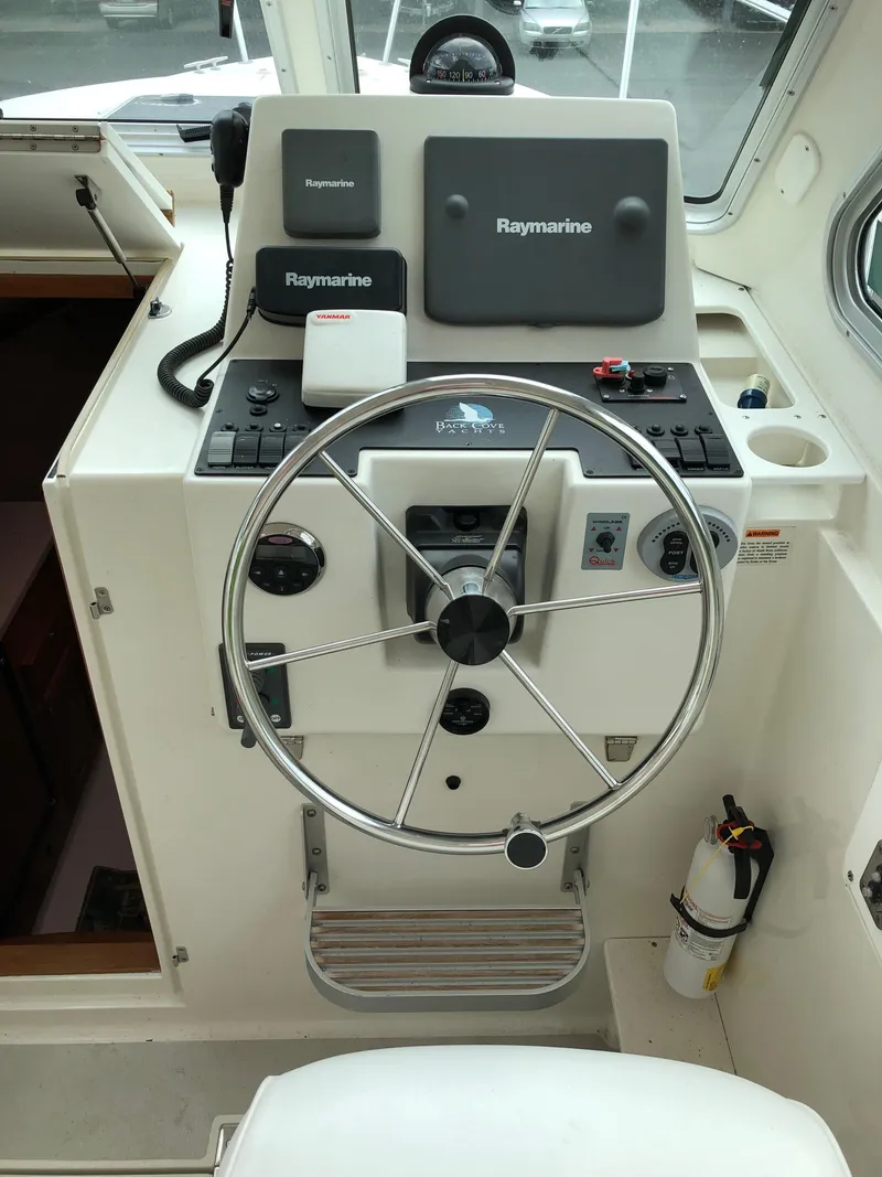 Slide: The Image of 2008 Back Cove 29 helm with Raymarine electronics and steering wheel. - 12