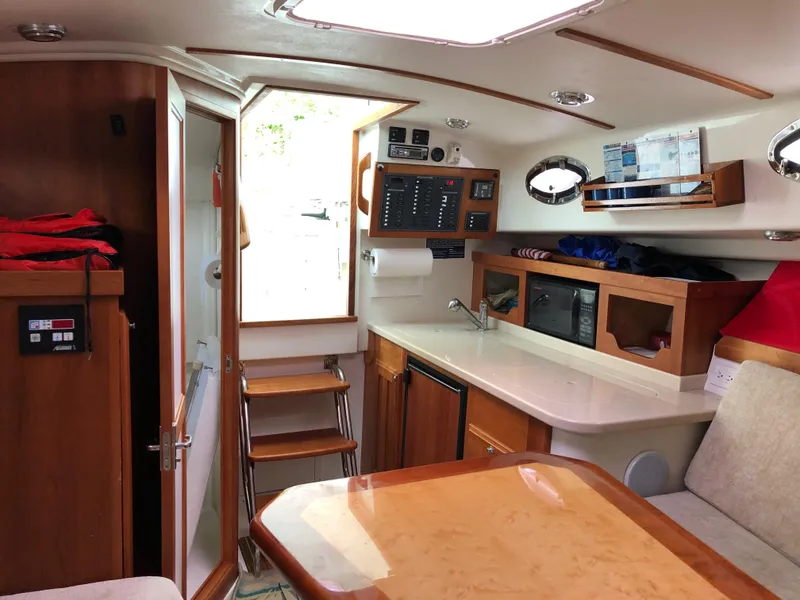 Slide: The Image of 2008 Back Cove 29 interior with wood finish, kitchenette, and seating area. - 17