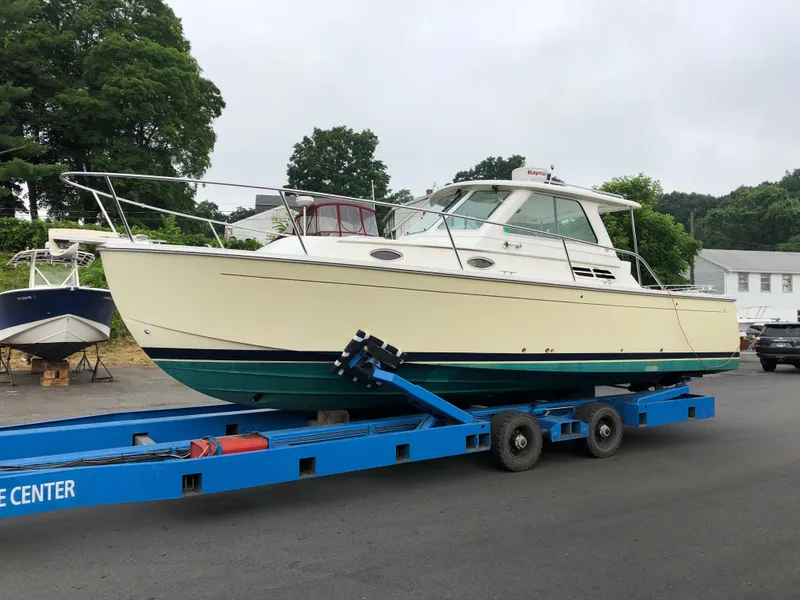 Slide: The Image of 2008 Back Cove 29 boat on a blue trailer, parked on a road. - 2