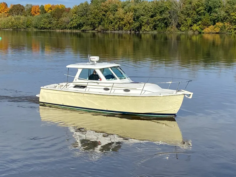 Slide: The Image of 2008 Back Cove 29 boat cruising on a calm lake with autumn trees in the background. - 29