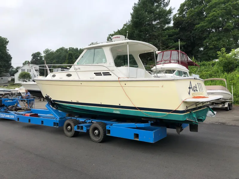 Slide: The Image of 2008 Back Cove 29 boat on trailer, parked outdoors, surrounded by trees and other boats. - 3