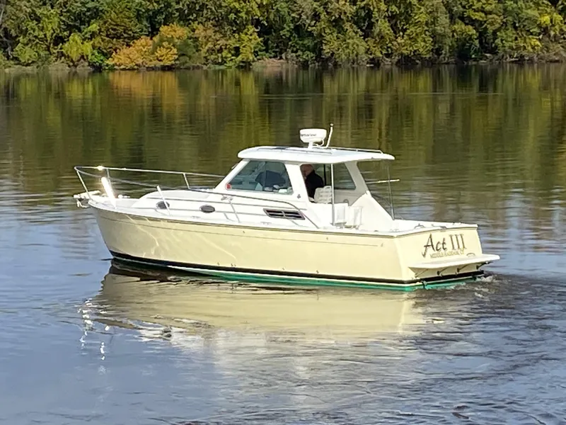 Slide: The Image of 2008 Back Cove 29 boat cruising on calm water with lush green background. - 33