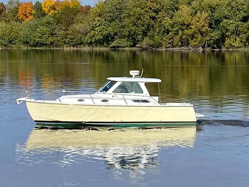 Slide: The Image of 2008 Back Cove 29 boat cruising on a calm lake with autumn trees in the background. - 34