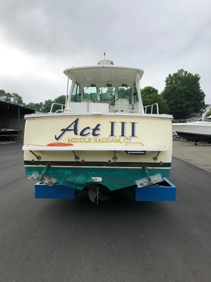 Slide: The Image of 2008 Back Cove 29 boat, rear view, docked, with "Act III" name displayed. - 6