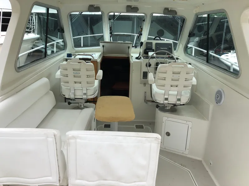 Slide: The Image of 2008 Back Cove 29 boat interior with helm, seating, and windows. - 9