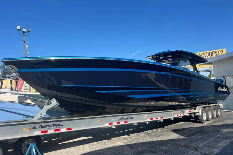 The Image of 2026 Nor-Tech 450 Sport boat on trailer, sleek design, blue accents, under clear sky. - 0