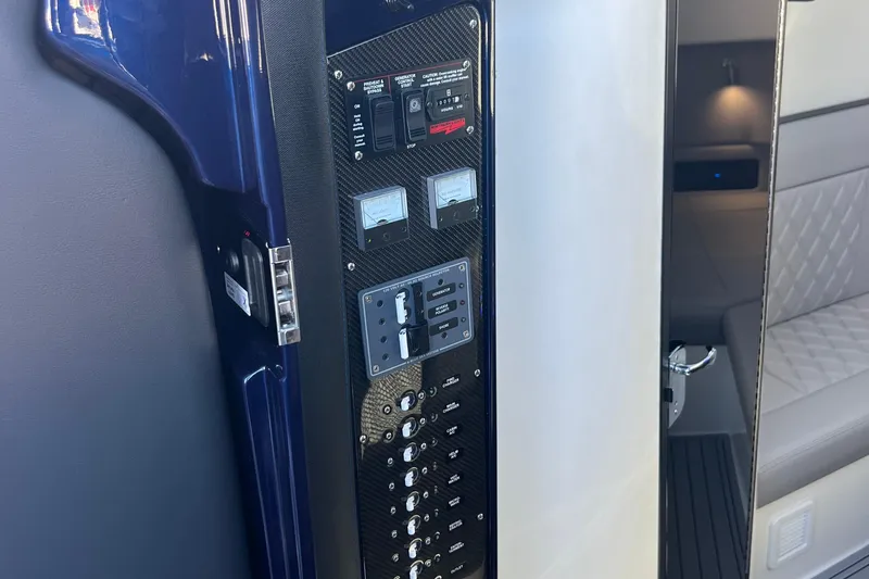 Slide: The Image of Control panel inside 2026 Nor-Tech 450 Sport boat, featuring switches and gauges. - 51