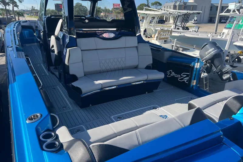 Slide: The Image of 2026 Nor-Tech 450 Sport boat interior with blue and gray seating, docked outdoors. - 8