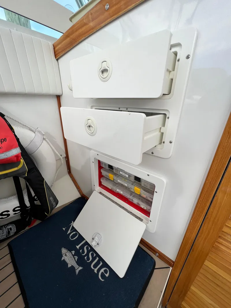 Slide: The Image of 1984 Bertram 26 Express boat interior with storage compartments and control panel. - 19