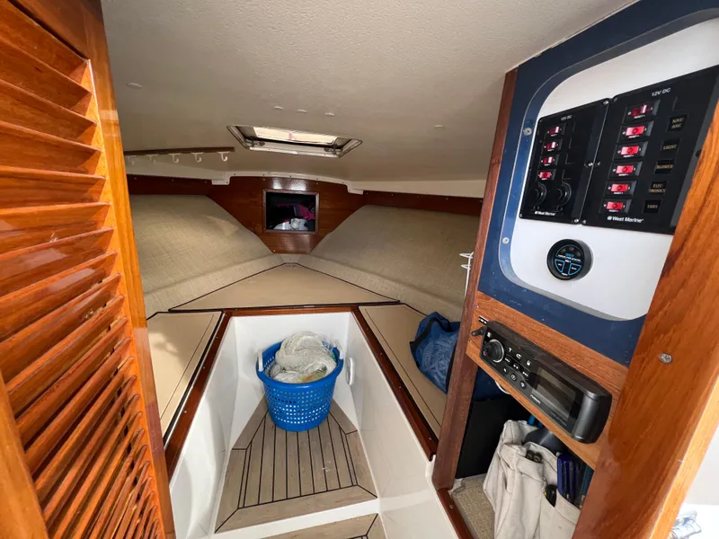 Slide: The Image of 1984 Bertram 26 Express cabin interior with control panel and seating area. - 24