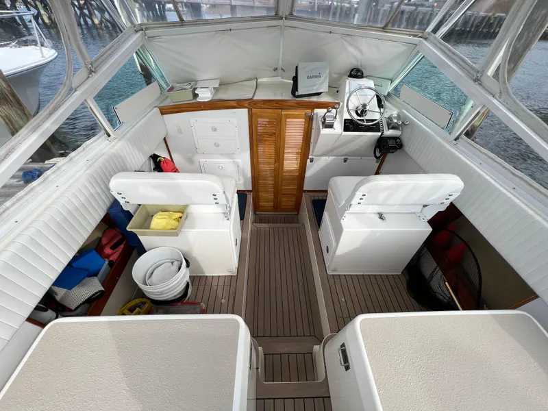 Slide: The Image of 1984 Bertram 26 Express boat interior with seating, steering wheel, and storage compartments. - 28