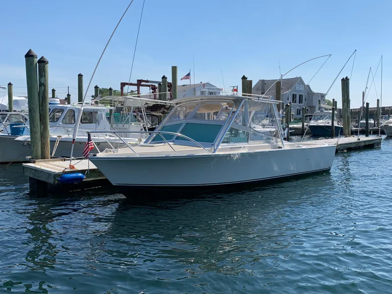 Slide: The Image of 1984 Bertram 26 Express boat docked at a marina on a sunny day. - 3