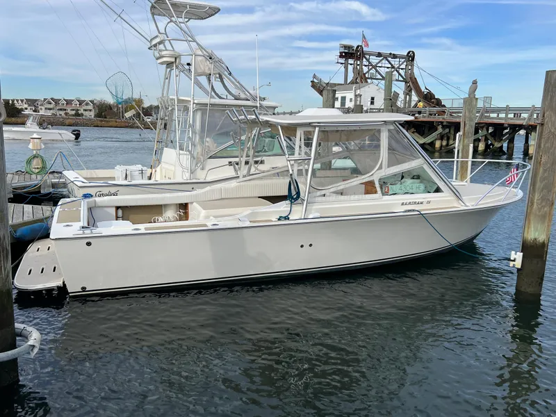 Slide: The Image of 1984 Bertram 26 Express boat docked in a marina, clear sky, calm water. - 31