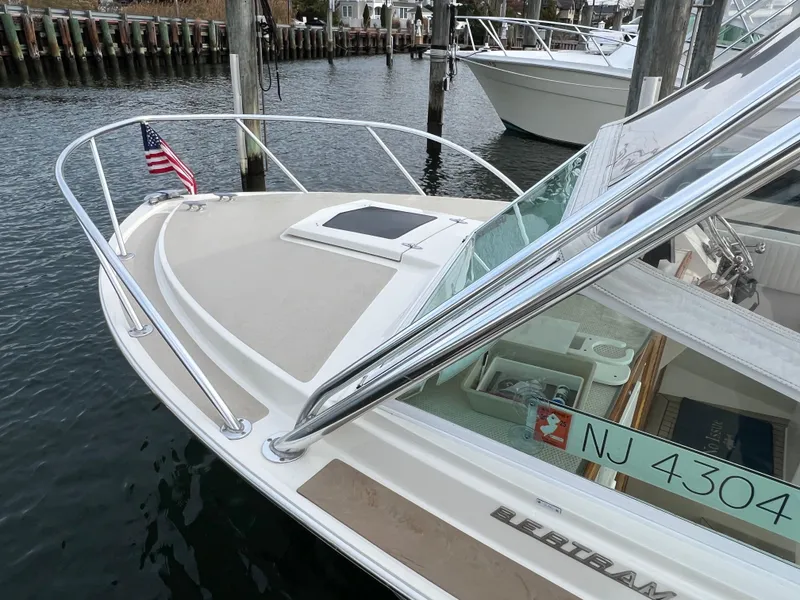 Slide: The Image of 1984 Bertram 26 Express boat docked, featuring sleek design and American flag. - 4