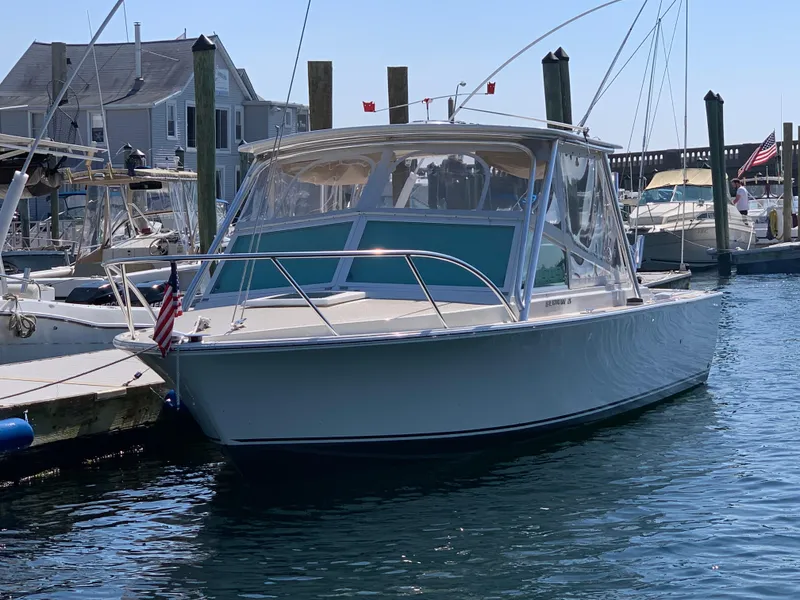 Slide: The Image of 1984 Bertram 26 Express boat docked in a marina, clear sunny day. - 7