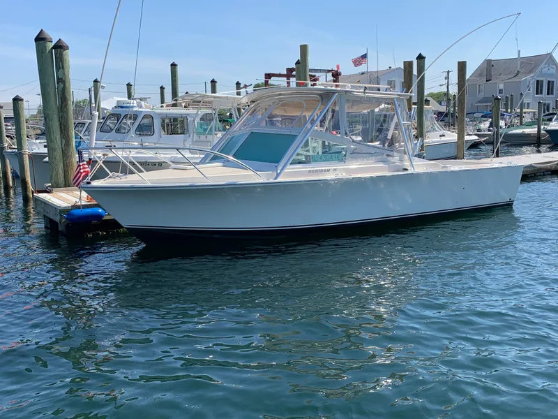 Slide: The Image of 1984 Bertram 26 Express boat docked in a marina on a sunny day. - 8