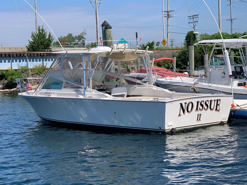 Slide: The Image of 1984 Bertram 26 Express boat named "No Issue II" docked in a marina. - 9