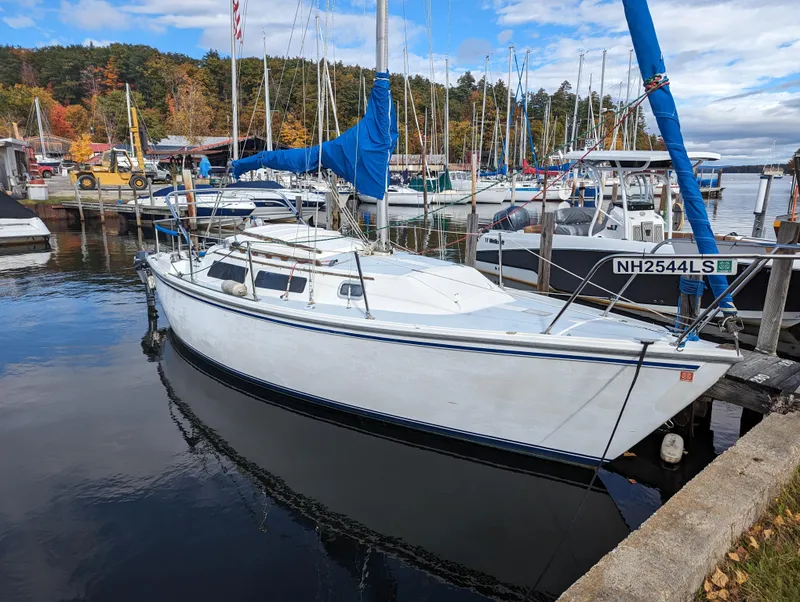 The Image of 1987 Catalina 25 sailboat docked at a marina with other boats. - 0