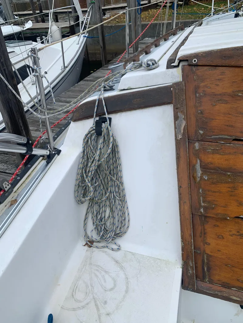 Slide: The Image of 1987 Catalina 25 sailboat cockpit with coiled rope and wooden hatch. - 12