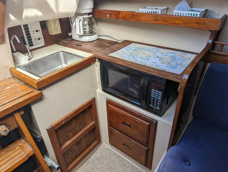 Slide: The Image of Compact kitchen area in a 1987 Catalina 25 sailboat with sink, microwave, and coffee maker. - 15