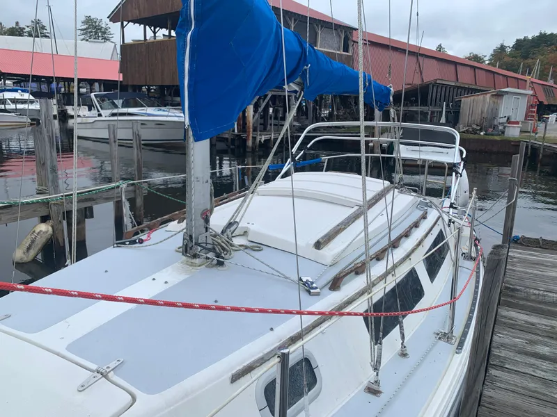 Slide: The Image of 1987 Catalina 25 sailboat docked at a marina with blue sail cover. - 5