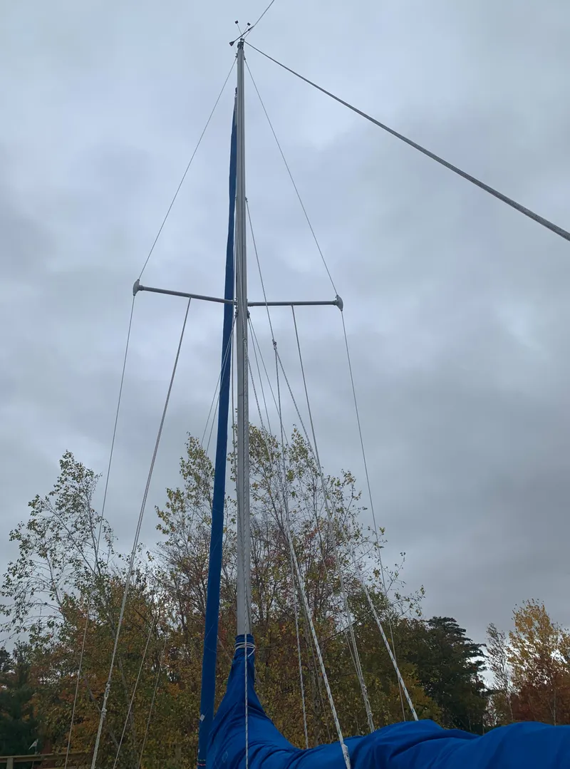 Slide: The Image of 1987 Catalina 25 sailboat mast against cloudy sky and autumn trees. - 8
