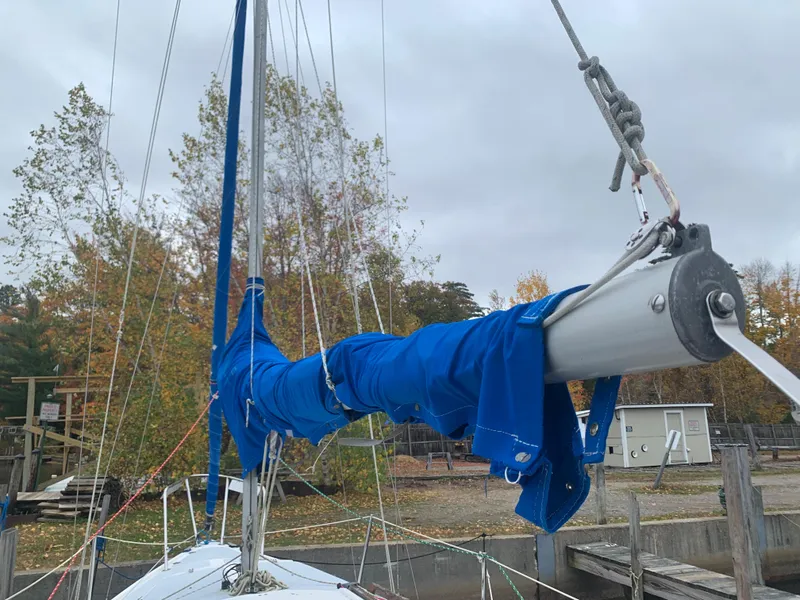 Slide: The Image of 1987 Catalina 25 sailboat with blue sail cover docked in a marina. - 9