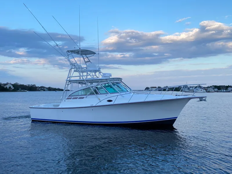 The Image of 2025 Henriques 35 Express boat on calm water with blue sky background. - 0