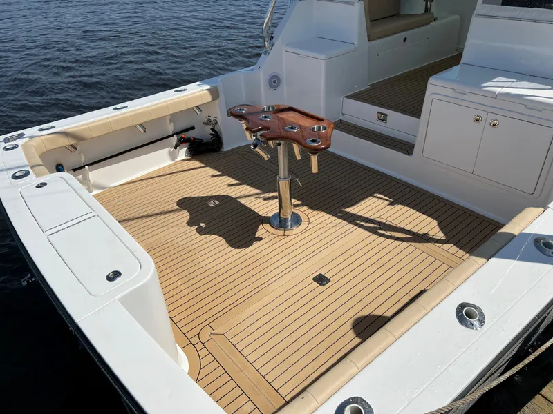 Slide: The Image of 2025 Henriques 35 Express boat deck with teak flooring and fishing rod holder. - 10