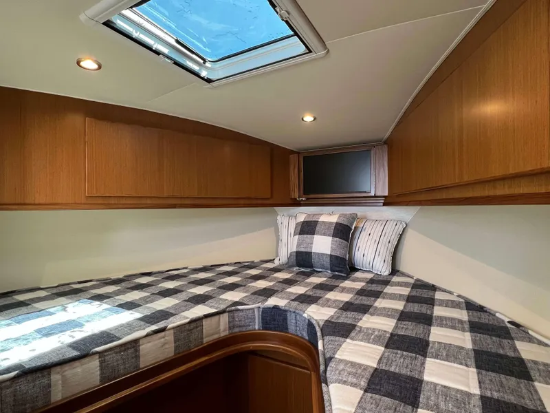 Slide: The Image of 2025 Henriques 35 Express cabin with skylight and plaid bedding. - 16