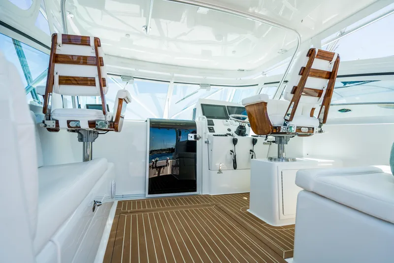 Slide: The Image of 2025 Henriques 35 Express boat interior with wooden accents and modern seating. - 7