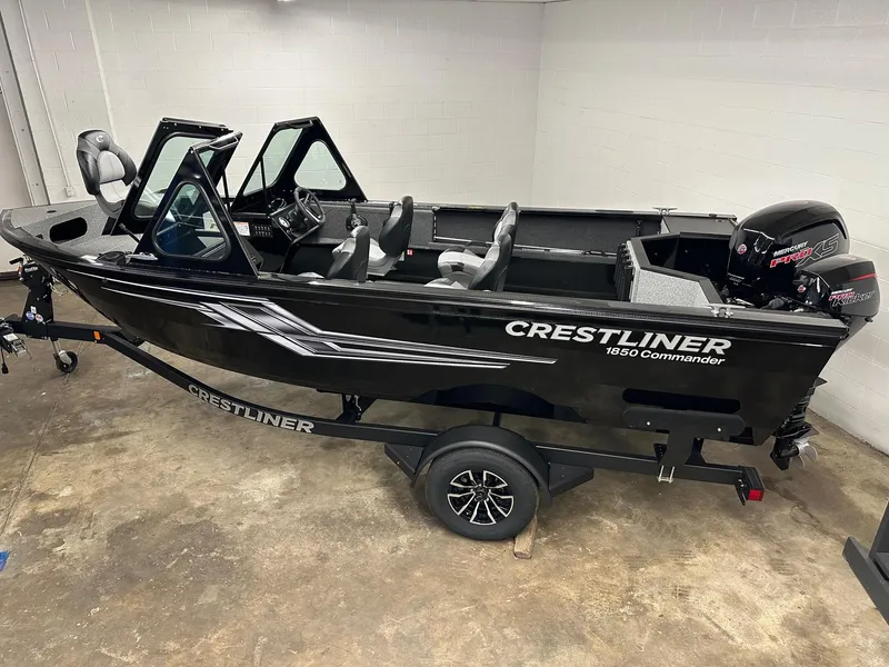 Slide: The Image of 2025 Crestliner 1850 Commander boat in showroom, black exterior, on trailer. - 0