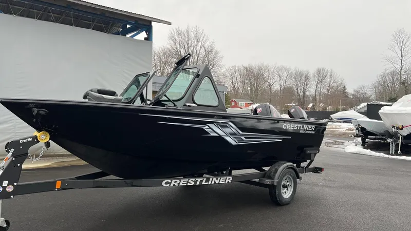 Slide: The Image of 2025 Crestliner 1850 Commander boat on trailer, black exterior, parked outdoors. - 2