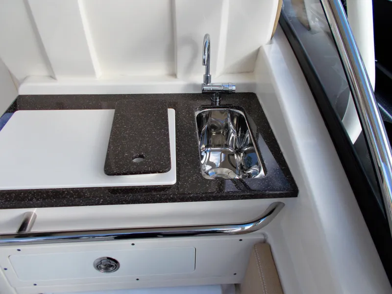 Slide: The Image of Scout 255 Dorado 2026 boat kitchenette with sink and cutting board. - 21
