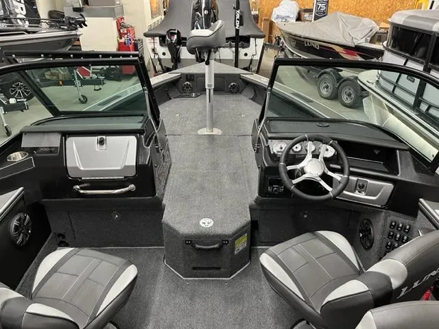 Slide: The Image of Interior of a 2025 Lund 2075 Pro V Sport fishing boat with seating and steering console. - 3