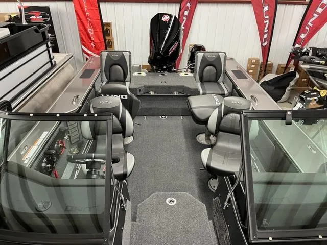 Slide: The Image of 2025 Lund 2075 Pro V Sport fishing boat interior with seating and motor. - 6