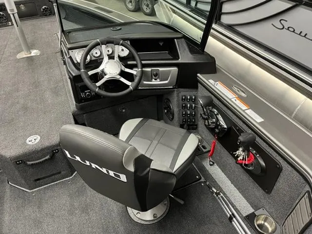 Slide: The Image of 2025 Lund 2075 Pro V Sport boat cockpit with steering wheel and control panel. - 7