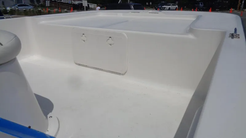 Slide: The Image of 2015 Key West 177 Skiff boat interior, featuring spacious white deck and storage compartment. - 4