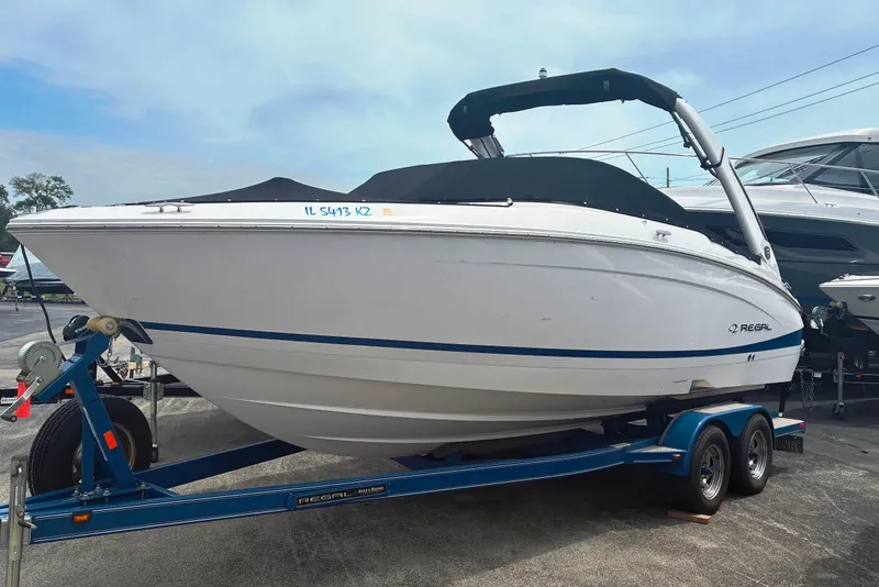 The Image of 2020 Regal LS4 boat on trailer, white with blue accents, parked outdoors. - 0