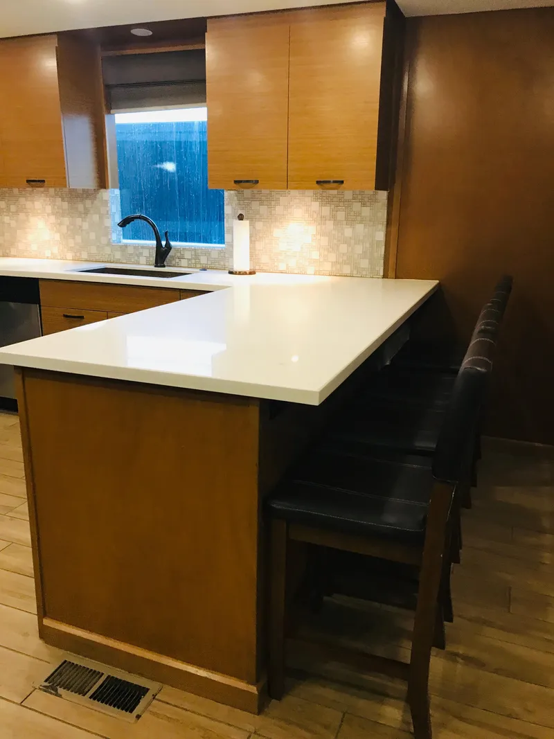 Slide: The Image of Modern kitchen with wooden cabinets, island, and bar stools in a 2014 Bravada Imagination Trip 11. - 17