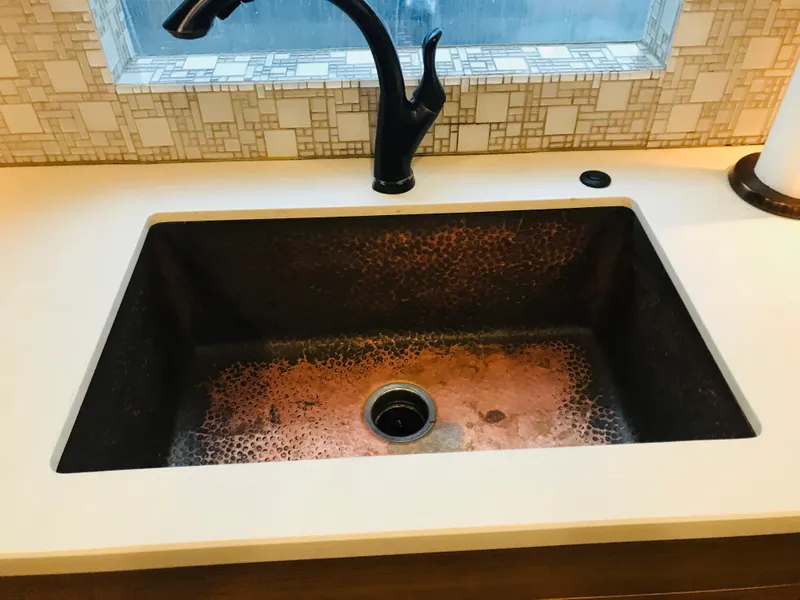 Slide: The Image of Copper sink with black faucet in modern kitchen setting. - 19